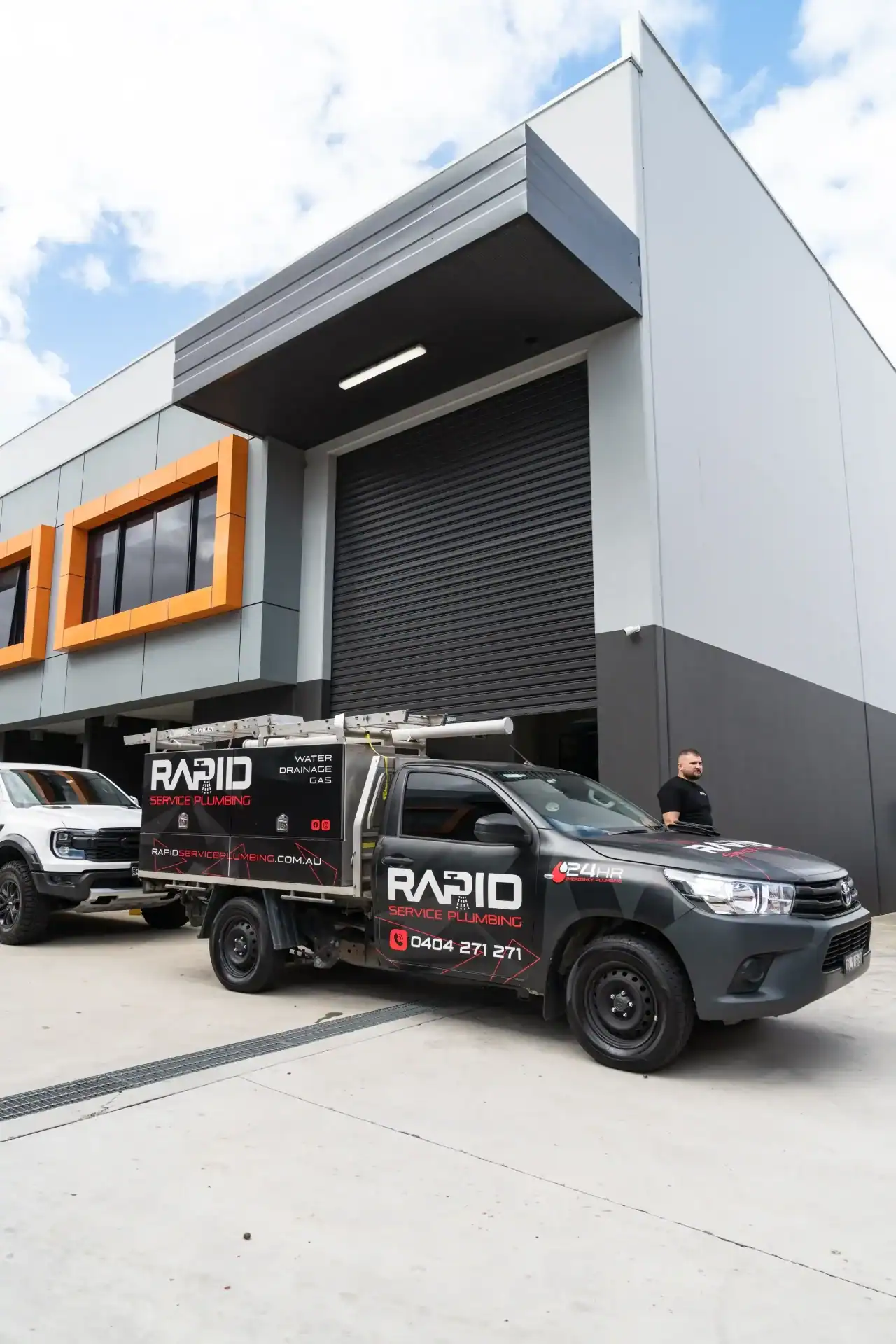 Rapid Service Plumbing branded ute parked outside modern Sydney warehouse, ready for burst pipe emergency repairs and plumbing services.