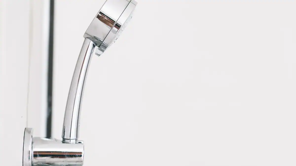 Chrome hand shower on a white bathroom wall