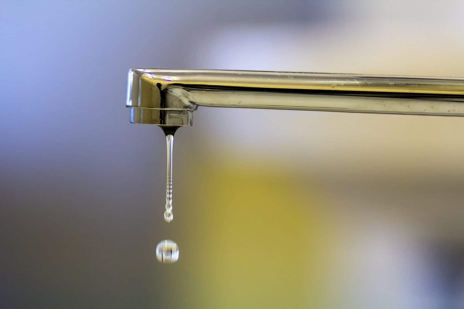 Close-up of faucet with turned drop water in modern bathroom. Horizontal crop with shallow depth of field