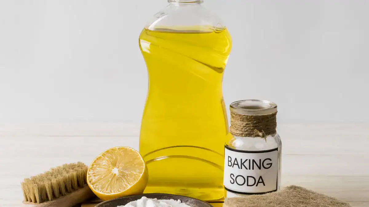 Bottle of dishwashing liquid beside a jar of baking soda and a lemon