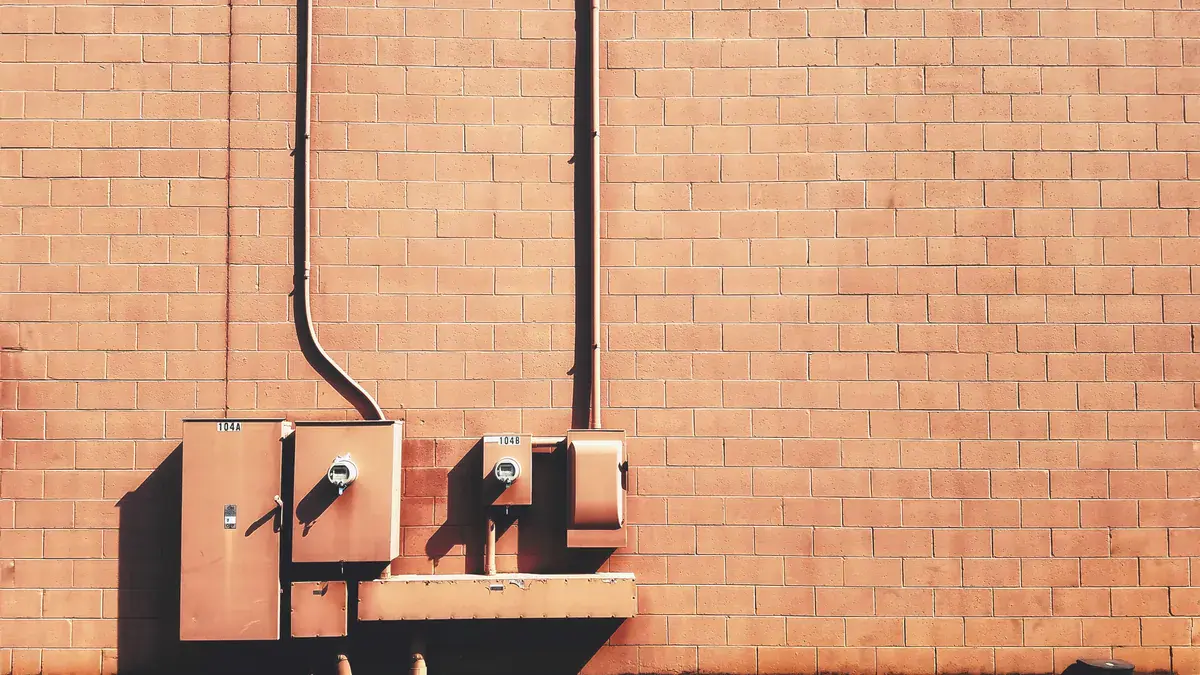 Electrical switchboard boxes mounted on an exterior brick wall
